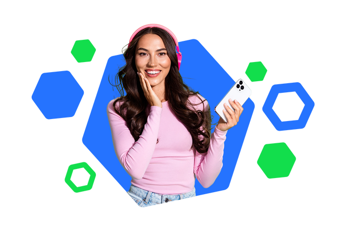 A young woman with long hair wears bright pink headphones and a matching long-sleeve top while holding a white smartphone. She appears to be listening to audio, with one hand touching the headphones and the other holding the phone. The background features a modern blue hexagonal shape with additional blue and green hexagons floating around. The overall composition feels playful and tech-focused, emphasizing digital lifestyle and music streaming.
