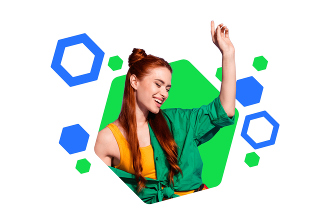 Eine junge Frau mit grünem Shirt und gelbem Top posiert vor einem farbenfrohen, geometrischen Hintergrund. Die Umgebung ist von blauen und grünen Hexagonformen geprägt und sorgt für einen dynamischen, modernen Look. Ihr rotes Haar setzt einen markanten Kontrast zur lebendigen Farbpalette.