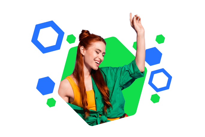 Eine junge Frau mit grünem Shirt und gelbem Top posiert vor einem farbenfrohen, geometrischen Hintergrund. Die Umgebung ist von blauen und grünen Hexagonformen geprägt und sorgt für einen dynamischen, modernen Look. Ihr rotes Haar setzt einen markanten Kontrast zur lebendigen Farbpalette.