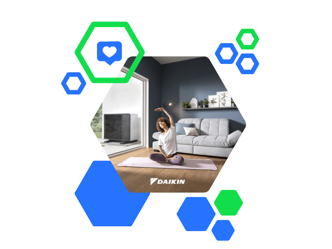 Ein Daikin-Außengerät für Heizung/Klima ist neben einem blauen Haus installiert. Zwei Techniker:innen, ein Mann und eine Frau, stehen in der Nähe und besprechen den Aufbau. Die Szene spielt an einem sonnigen Tag im Garten eines Wohnhauses, mit grünem Rasen und sichtbaren Bäumen. Das Daikin-Logo ist deutlich auf dem Gerät zu sehen.